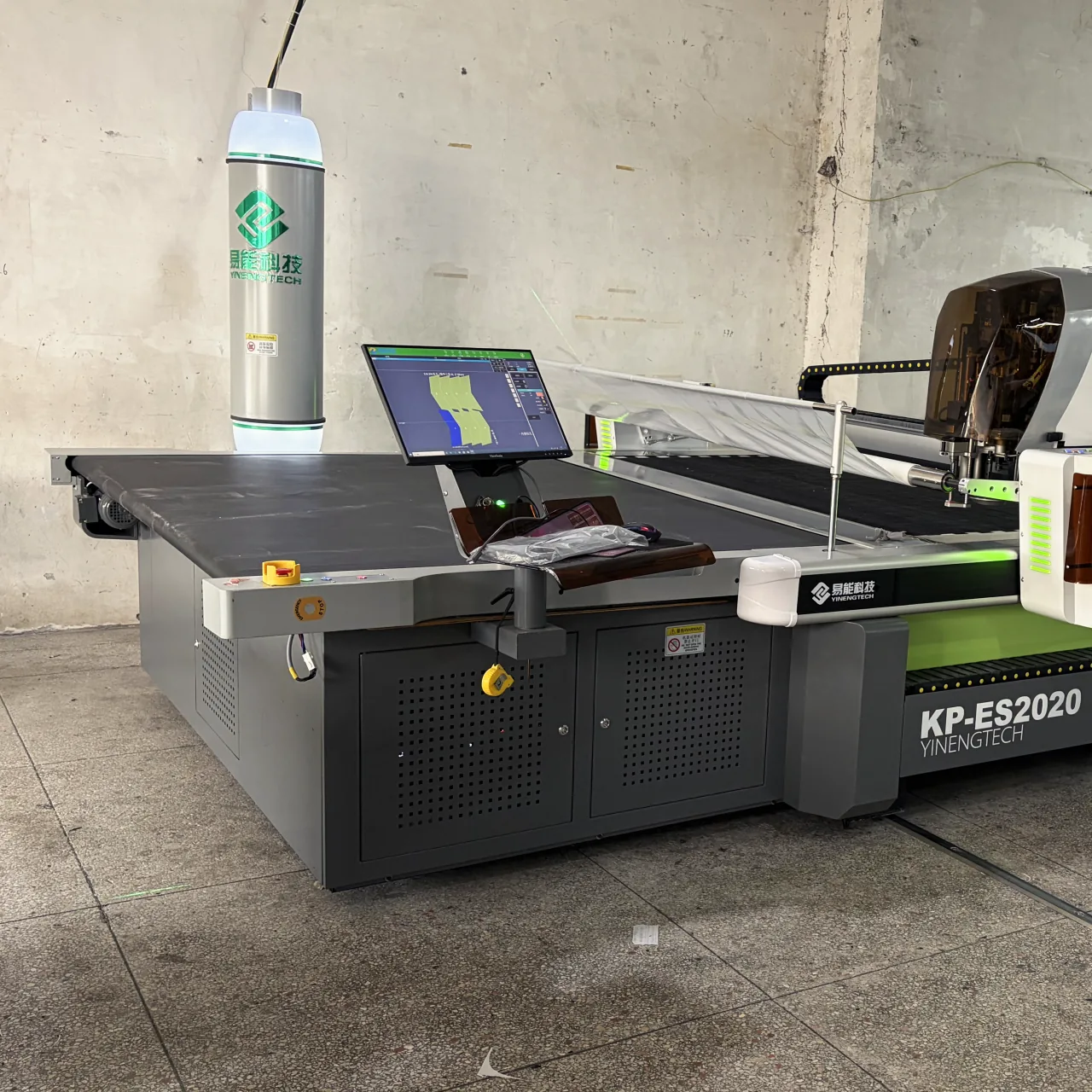 An automatic cutting table with its control screen showing a marker.