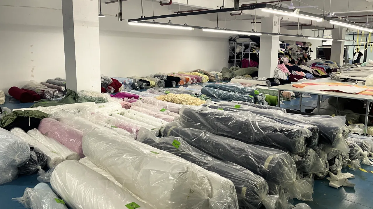 Rolls of fabric in plastic bags laid out on the floor of the fabric store.